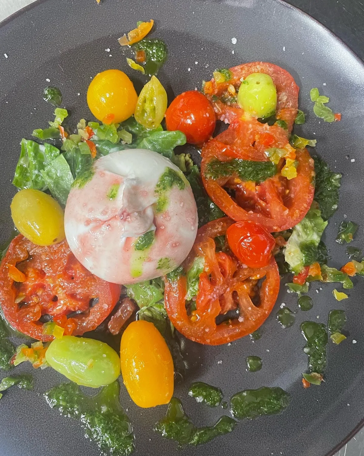 Burrata auf bunten Tomaten mit frischem Salat