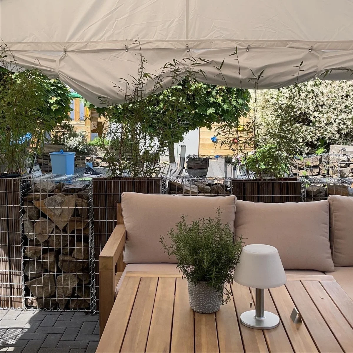 Terrasse mit gedeckten Tischen und Sonnenschutz